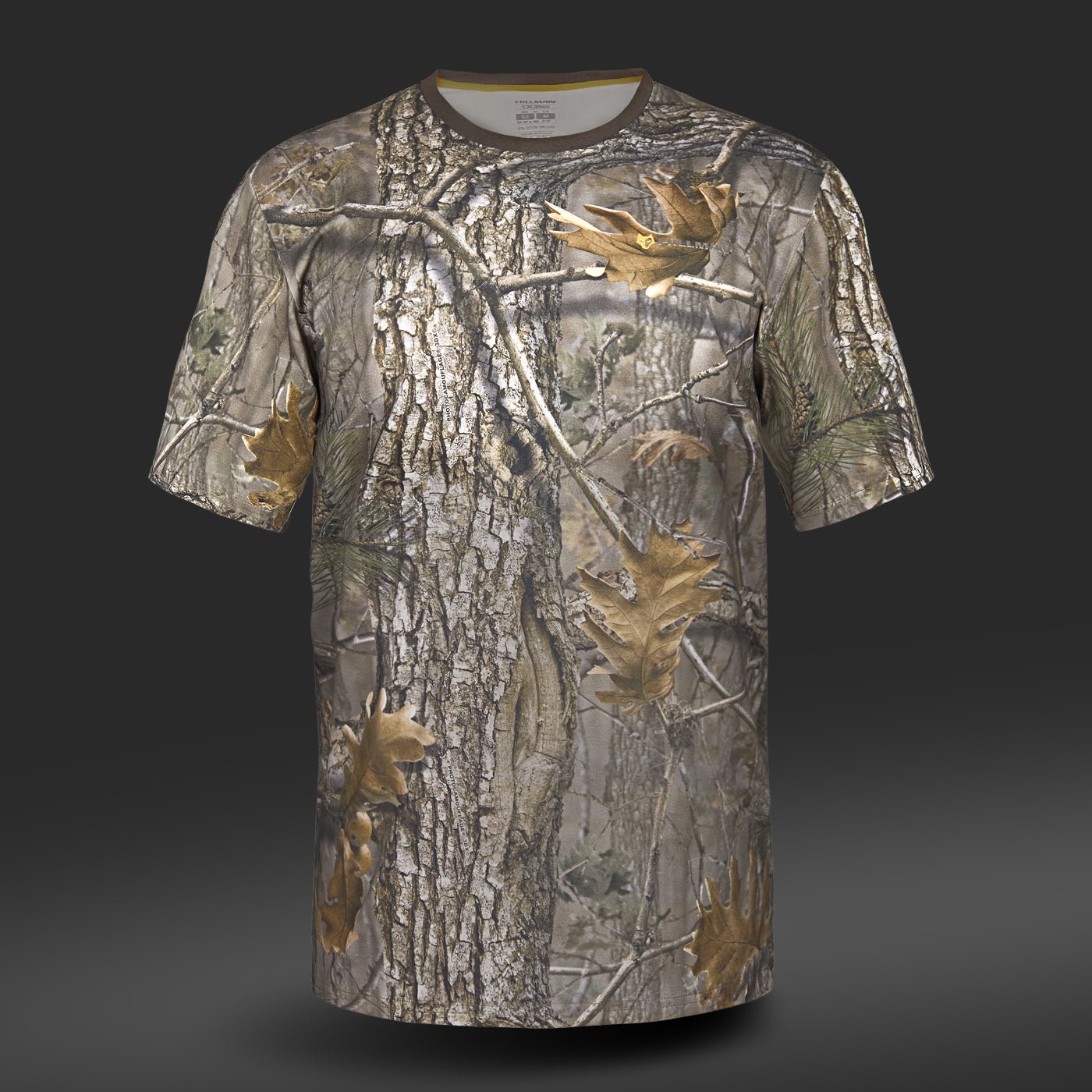 Hillman® Tricou Vanatoare din Bumbac DGT - Maneca scurta prezinta un model de camuflaj de padure realist cu scoarta de copac, frunze si ramuri pe un fundal gri inchis. Confectionat din moale Bumbac Egiptean, este ideal pentru pasionatii de imbracaminte de vanatoare care cauta confort si stil in aer liber.